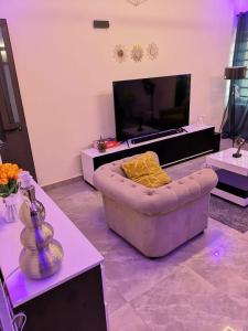 a living room with a couch and a flat screen tv at YAYA in Cotonou