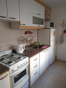 a kitchen with a white stove and a sink at Confortable departamento. Excelente ubicación in Buenos Aires