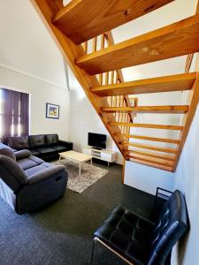 a living room with a couch and a table at Just Beachy Loft Villa in Mandurah
