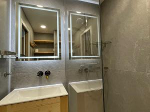 ein Bad mit einer Dusche, einem Waschbecken und einem Spiegel in der Unterkunft Studio Méribel, 1 pièce, 4 personnes - FR-1-411-382 in Les Allues