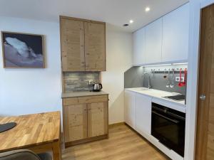 eine Küche mit weißen Schränken und einem Holztisch in der Unterkunft Studio Méribel, 1 pièce, 4 personnes - FR-1-411-382 in Les Allues