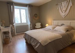 a bedroom with a large bed and a window at La ferme d'Auguste in Thorens-Glières