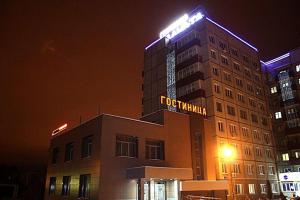 een hotelgebouw met een bord erop bij Planeta Hotel in Tsjeljabinsk