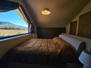 1 dormitorio con 1 cama y ventana grande en Kallisto villas, en Kalívia