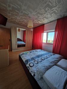 a bedroom with a large bed with red curtains at Z Villa in Bucharest