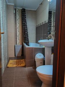a bathroom with a toilet and a sink and a tub at Z Villa in Bucharest