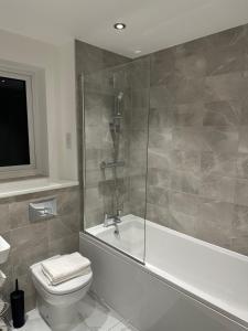 y baño con bañera, aseo y ducha. en Lush Place en Mánchester