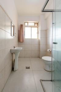 a white bathroom with a sink and a toilet at Apto 3qts centro - vista cartão postal in Belo Horizonte