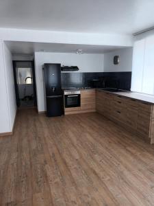 a large kitchen with wooden floors and appliances in a room at Appart de charme au bord de l'eau 