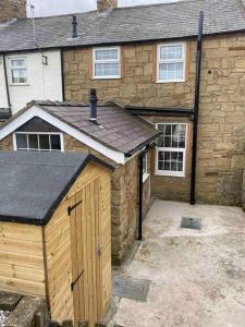 una casa con un garage in legno di fronte di 43 Heol Maelor- A Homely Cottage in Wrexham, North Wales a Coedpoeth
