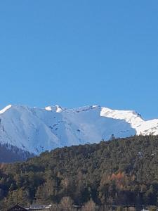 a snow covered mountain in the distance with a house at Ferienwohnung Bergblick in Imst