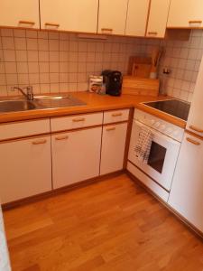 a kitchen with white cabinets and a sink and an oven at Ferienwohnung Bergblick in Imst