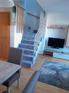 a living room with a staircase and a television at Ferienwohnung Bergblick in Imst