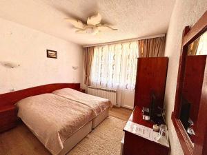 1 dormitorio con 1 cama y ventilador de techo en Guest House Meraklii, en Smilyan