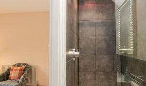 a shower with a glass door in a bathroom at Scandale Cottage in Ambleside