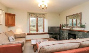 a living room with two couches and a fireplace at Scandale Cottage in Ambleside