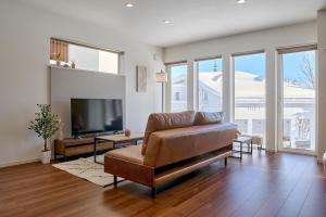 a living room with a couch and a flat screen tv at KOYO・YUKI in Furano