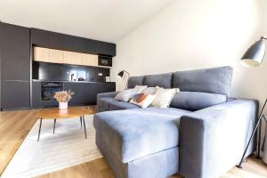 uma sala de estar com um sofá azul e uma cozinha em New! Superb & Bright Apartment in Lisbon em Lisboa