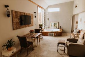uma sala de estar com uma banheira e uma mesa em Pousada Paty´s Garden em Florianópolis