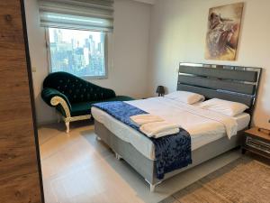 a bedroom with a bed and a chair and a window at Flora Rezidance Ataşehir in Istanbul