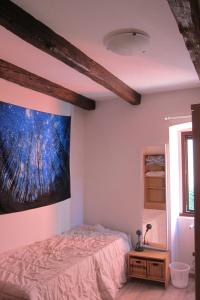 een slaapkamer met een bed en een schilderij aan de muur bij Camere Stone House in Trieste
