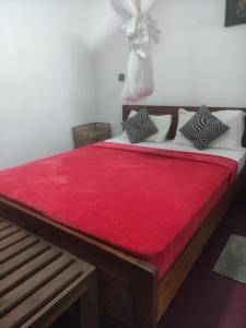 Cama en habitación con manta roja en Nice Ella, en Ella