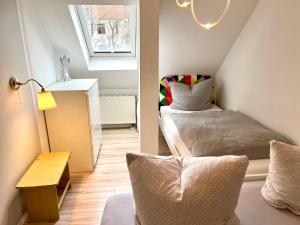ライプツィヒにあるHinterhaus Apartmentsのベッドと窓が備わる小さな客室です。