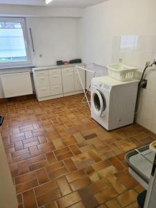 a kitchen with a washing machine on a tile floor at Gemütliches Gästehaus in ruhiger Waldlage in Büdingen