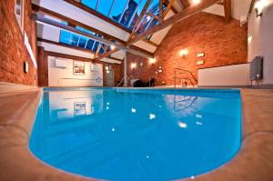 a large swimming pool in a building with a brick wall at Crown & Mitre Hotel in Carlisle