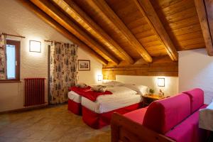 um quarto amplo com 2 camas e um sofá em Residence Monterosa em Macugnaga