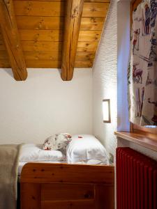 uma cama num quarto com tecto em madeira em Residence Monterosa em Macugnaga