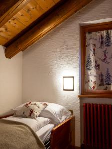 1 dormitorio con 1 cama y una pintura en la pared en Residence Monterosa, en Macugnaga