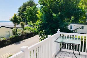 a bench sitting on a white fence on a porch at Family Seaside Retreat Private Stay at 5-Star Rockley Holiday Park Poole in Poole