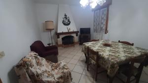 - un salon avec une table, des chaises et une cheminée dans l'établissement Casa con ingresso indipendente, à Zocca