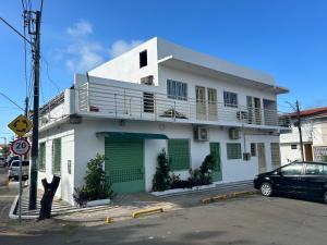 um edifício branco com portas verdes e um carro estacionado em frente em Betesda 2197E KITNET em São Luís