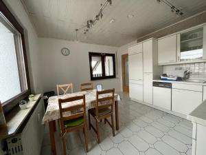 a kitchen with a table and chairs in a room at Ferienwohnung mit Balkon in Rodenbach