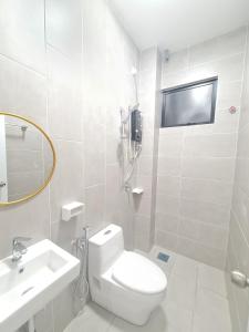 uma casa de banho branca com um WC e um lavatório em White Sweet Homestay, Kulim Hi-Tech Park Kedah utk MsIIim shj em Kulim