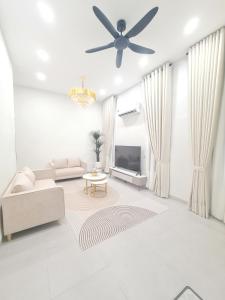 a living room with a ceiling fan and a television at White Sweet Homestay, Kulim Hi-Tech Park Kedah utk MsIIim shj in Kulim