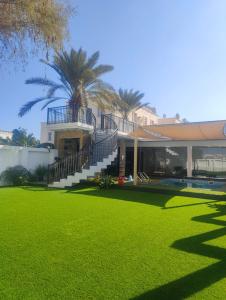 a house with a lawn in front of it at Munaya Chalet 2 منايا شاليه 2 in Ḩayl Āl ‘Umayr