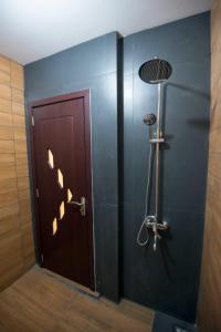 a bathroom with a shower with a door and a light at Munaya Chalet 2 منايا شاليه 2 in Ḩayl Āl ‘Umayr