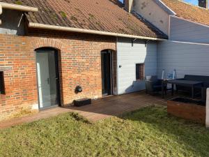 a wooden deck with a table and a house at Jolie petite maison solognote in Pierrefitte-sur-Sauldre