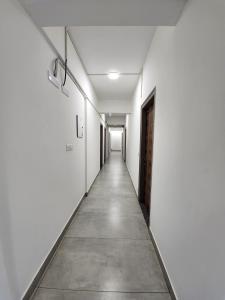 un pasillo vacío con paredes blancas y un pasillo largo en Hotel ksp kings inn, en Bangalore