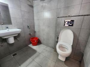 a bathroom with a toilet and a sink at Hotel ksp kings inn in Bangalore