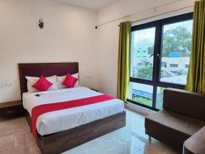 a bedroom with a bed and a large window at Hotel ksp kings inn in Bangalore