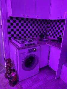 uma cozinha roxa com um fogão e um lavatório em Projeksiyonlu manzaralı daire em Duzce
