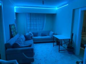 Habitación azul con sofá y mesa en Projeksiyonlu manzaralı daire, en Duzce