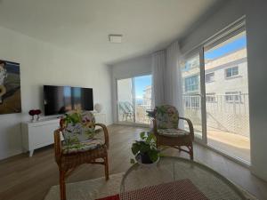 sala de estar con 2 sillas y TV de pantalla plana en Apartamento Centro Nerja proxi playas, en Nerja