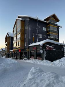 un grand bâtiment avec de la neige devant lui dans l'établissement Levin Kunkku C4, à Levi