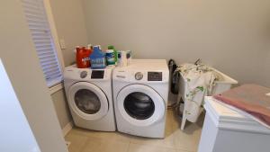 una lavatrice e asciugatrice in una piccola stanza di LUXURY 2-BEDROOMS UNIT WITH WIFI, LDR & PARKING. a Cambridge