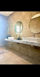 a bathroom with a sink and a mirror at Villa California vue Atlas avec piscine chauffée in Marrakesh